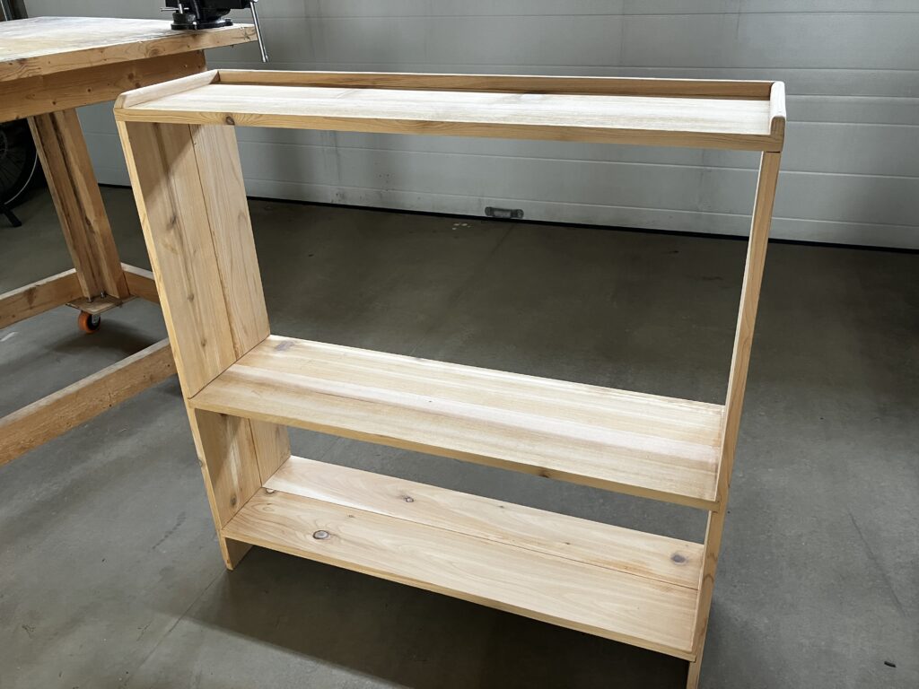 A cedar shelf with a spot for tall boots above the middle shelf.